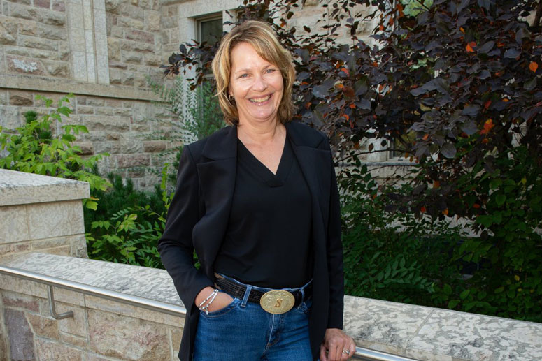 Dr. Shelley Kirychuk (PhD) stands in front of a building on the USask campus