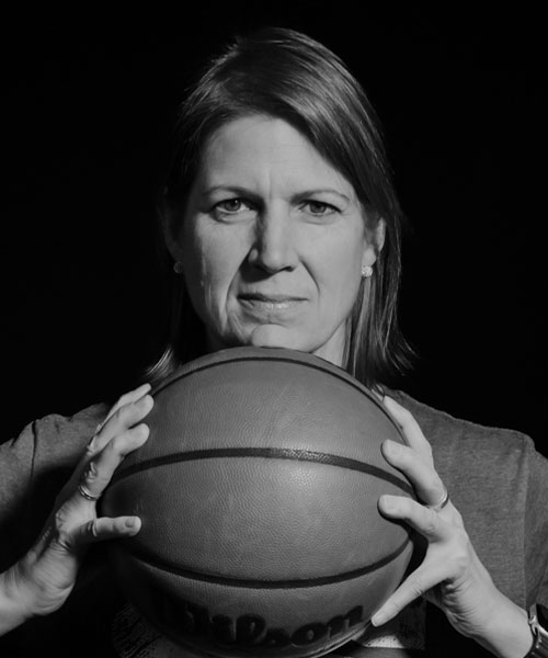 Black and white image of Lisa Thomaidis holding a basketball between her palms